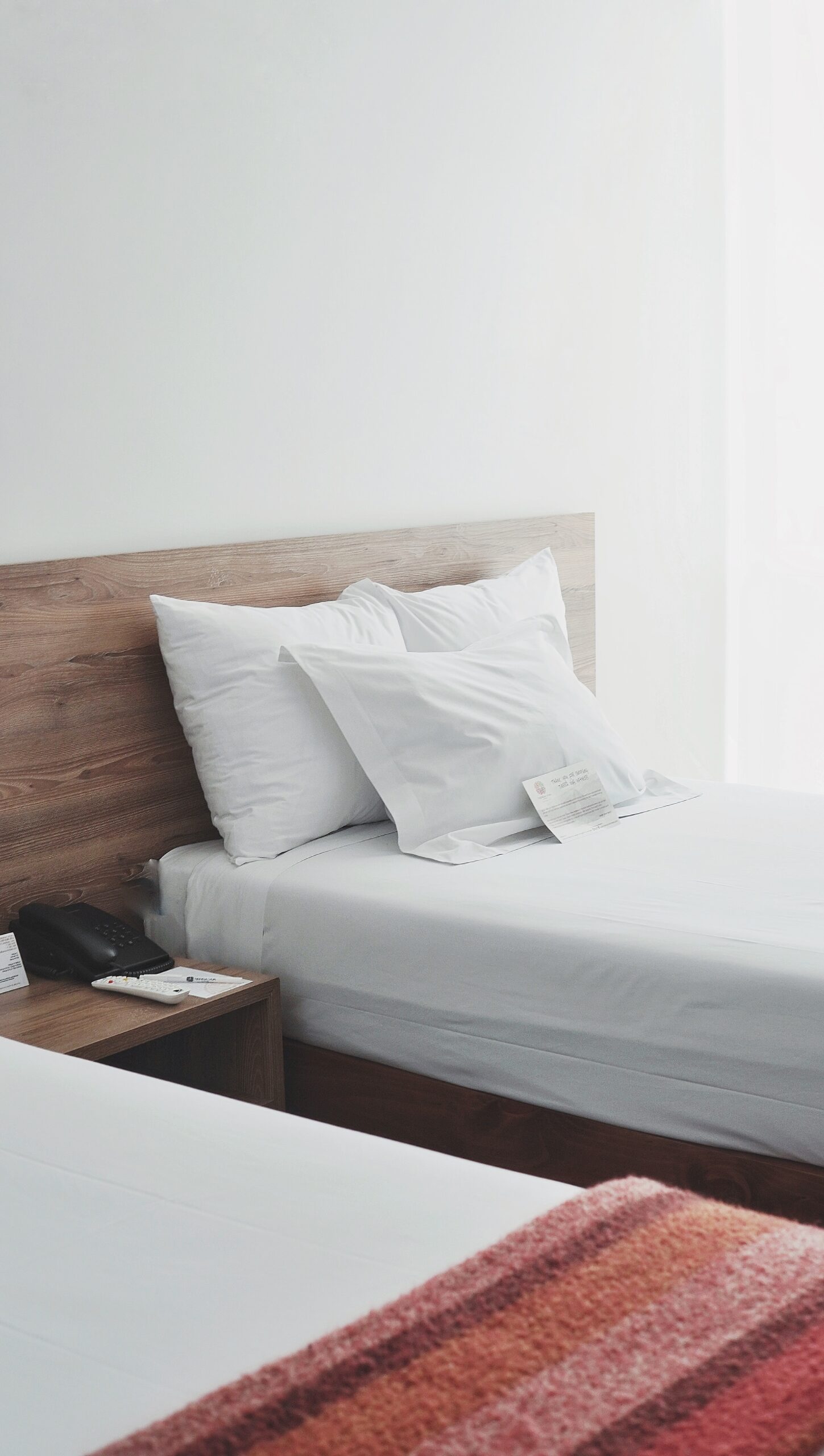 Two single beds in a bright hotel room.